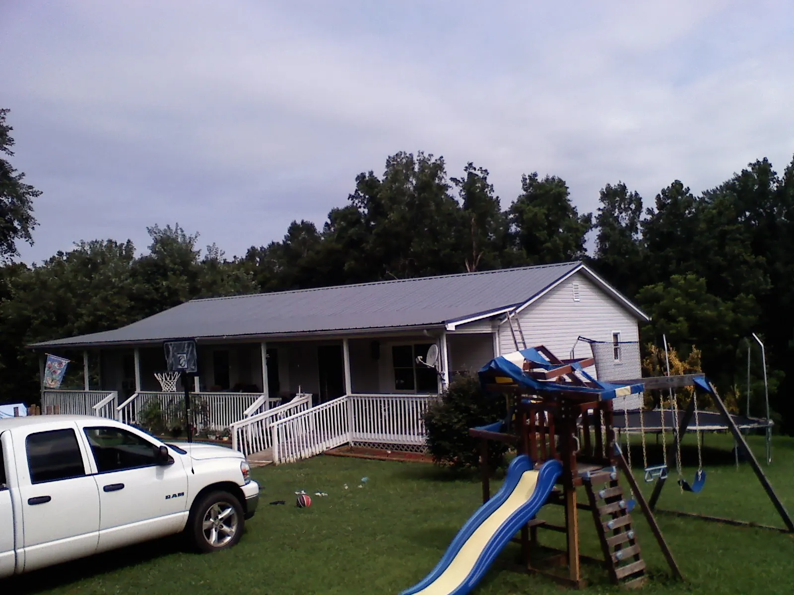 Dark metal roof on a country home with a full length front porch in Gaylord